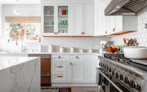 A white kitchen with stainless stovetop showing what it looks like when you know how to fix an awkward kitchen layout.